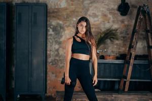 Young woman posing at the camera with dumbbells in her hands. photo