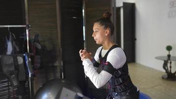 entrenamiento ems. chica haciendo ejercicios en un traje con cables. foto