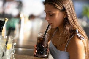 Woman resting on the beach bar, drink a refreshing cocktail. photo