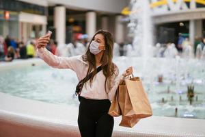 Woman using smartphone indoor. Texting and communicating in mall photo