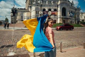 mujer joven con bandera nacional de ucrania en la calle foto