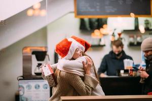 The girl gives a gift to her female friend in caffe photo