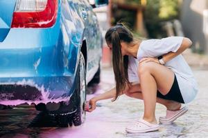 Brunette with two pigtails with a sponge washes the rim photo