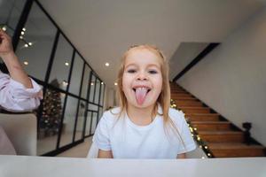 niña sacando la lengua al primer plano de la cámara foto