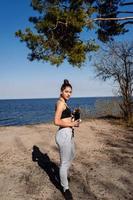 mujer joven fitness camina en el parque y posa para la cámara foto
