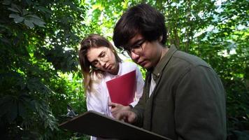 Young agricultural engineers working in greenhouse photo