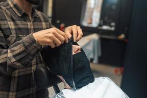 Barber preparing man face for shaving with hot towel in barber shop photo