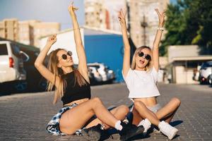 Two young, sexy girls are sitting on the ground photo