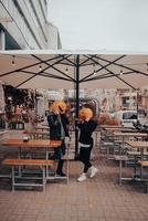 chico y chica con cabezas de calabaza en un café de la calle foto