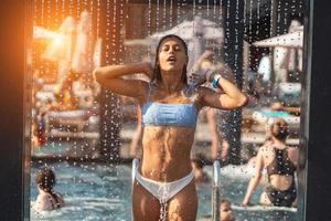 Beautiful Girl In Swimwear Showering Under Water At Resort Beach. photo