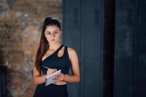 mujeres jóvenes de pie escribiendo algo en el cuaderno. foto