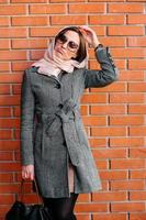 girl posing on a background of red brick wall photo