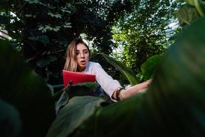 Young agricultural engineer examines leaves in greenhouse photo