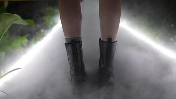 A girl walks in a greenhouse, fog spreads on the ground photo