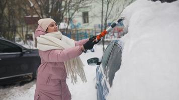 Woman removing snow from car photo