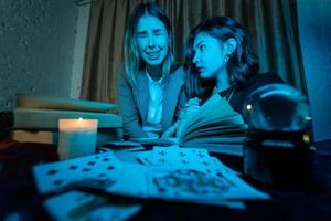 Two women are reading a mysterious book photo