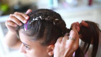 Process of braiding. Master weaves braids on head in a beauty salon, close up photo