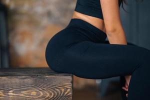 Sporty woman in sportswear resting on bench at fitness. photo