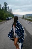 Tourist woman walking on a highway in the mountains photo