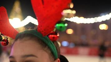 People enjoy ice skating in the street around Christmas tree in rink. photo