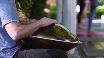 A close up of male hands playing Handpan Drum photo
