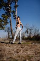 Fitness young woman walks in the park and posing for the camera photo