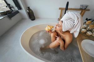 Luxury fashion woman in the morning take breakfast lying in bath photo