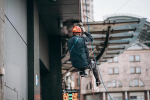 Industrial climber in uniform and helmet rises photo