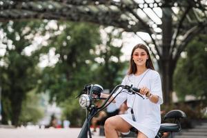 mujer hermosa joven y un scooter eléctrico, transporte ecológico foto