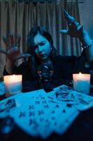 Woman fortune-teller guesses fate of night at table with candles photo