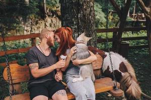 hermosa pareja junto con un perro en un columpio foto