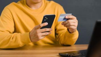 A man using credit card for purchasing and shopping online on mobile phone. Mobile payment with wallet app technology. Digital money transfer, banking and e commerce concept. photo