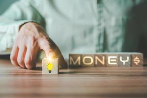 Businessman's hand scrolling the light bulb creative idea icon on wooden cube block forword. Business growth in concept. photo