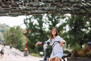 mujer hermosa joven y un scooter eléctrico, transporte ecológico foto