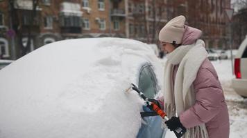 Woman removing snow from car photo