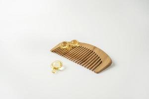 Hair care serum or smoothing oil lying on a wooden comb photo