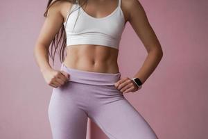 Slender girl in sportswear shows a tight figure and a tummy. photo