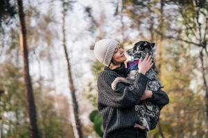 A girl is holding a mongrel dog in her arms. Caring for animals. photo