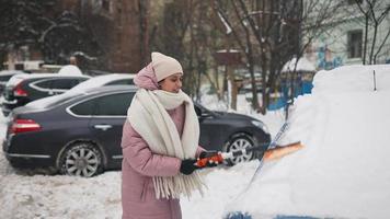 Woman removing snow from car photo