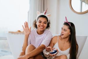 Two girls in the bath playing with face cream photo