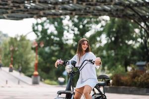 Young beautiful woman and an electric scooter, ecological transport photo