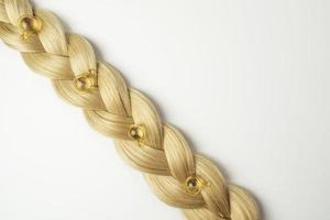 A natural essential oil or serum for hair care in golden capsules lying on a strand of  blonde hair. Hair care and smoothing concept photo