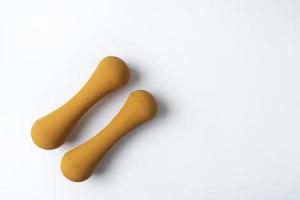 Two orange fitness dumbbells lying on the white background photo