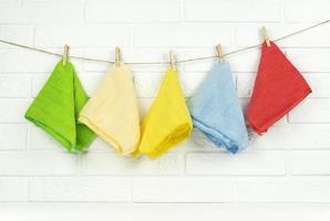 Colorful microfibre rags hang on a string in the kitchen photo