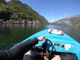 Man controls a motorboat on a mountain lake photo