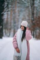 Young girl standing in the middle of snowy road. photo