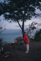 Young woman preparing food on the grill by the sea photo