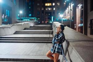 Woman talking on a smartphone on the night city photo