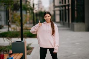 Playful portrait of pretty young woman, having fun at the street. photo