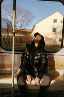 Young woman sitting on the background of a window in public transport photo